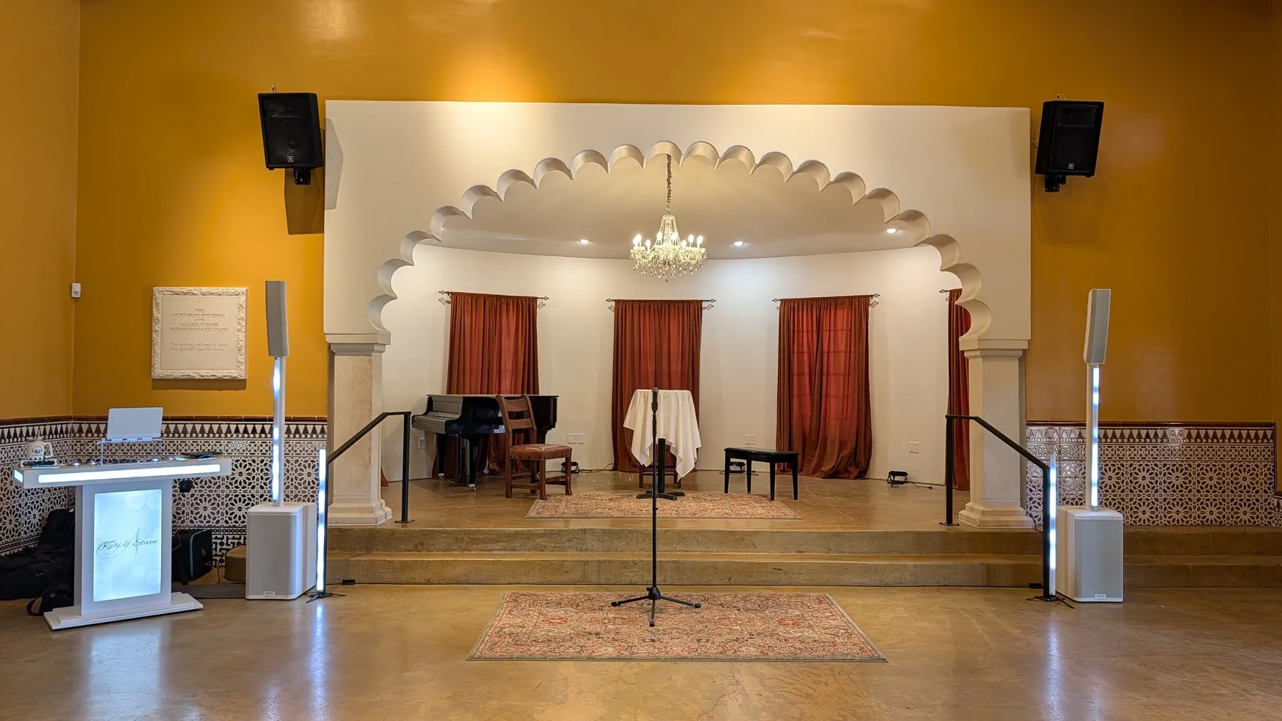 The ceremony stage inside Animante de Rondeña, with a piano, chandelier, and Cutmaster Music speaker towers flanking the arched alcove
