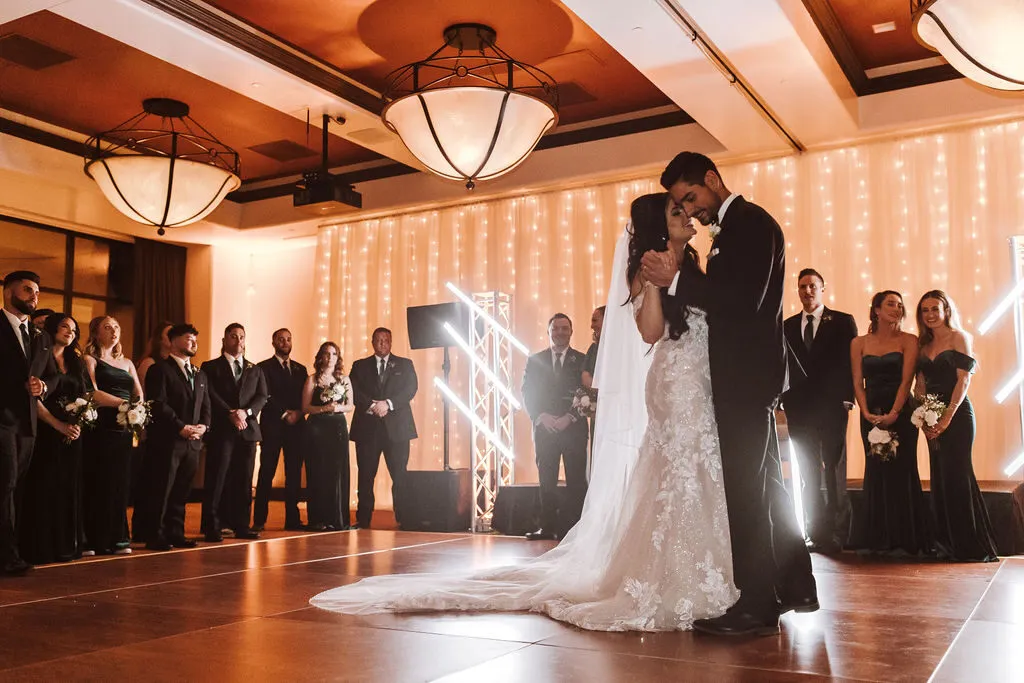 A couple's first dance under warm, simple lighting.