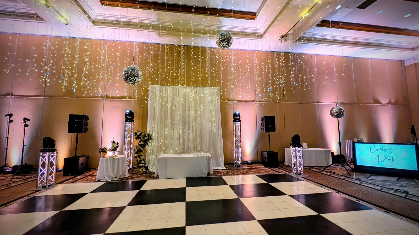 A Cutmaster Music setup in a Hotel Albuquerque ballroom, with disco balls and a string-light backdrop over a checkered dance floor