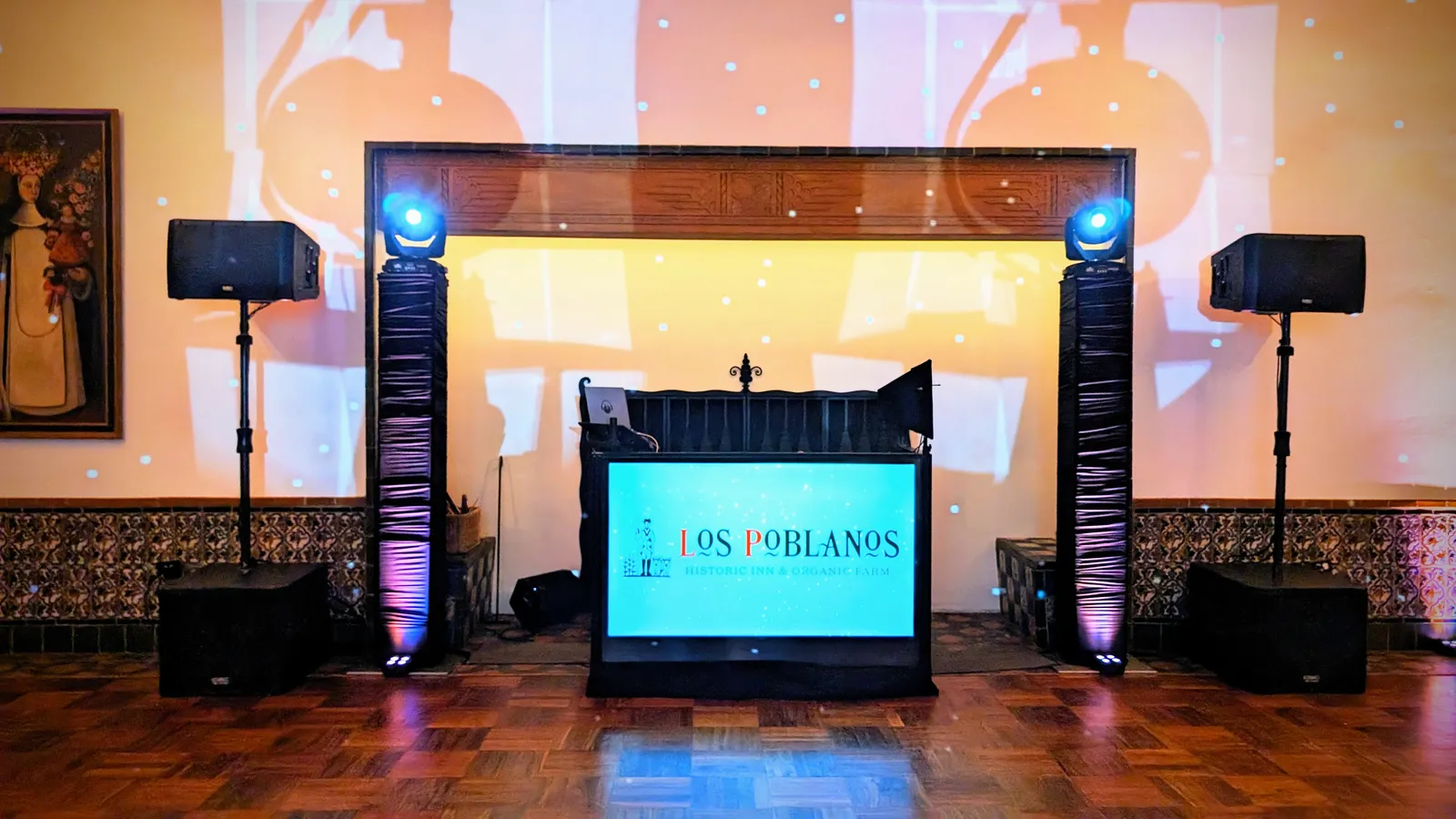 A Cutmaster Music DJ setup at Los Poblanos, in a tiled, wood-beamed room with a carved stone fireplace