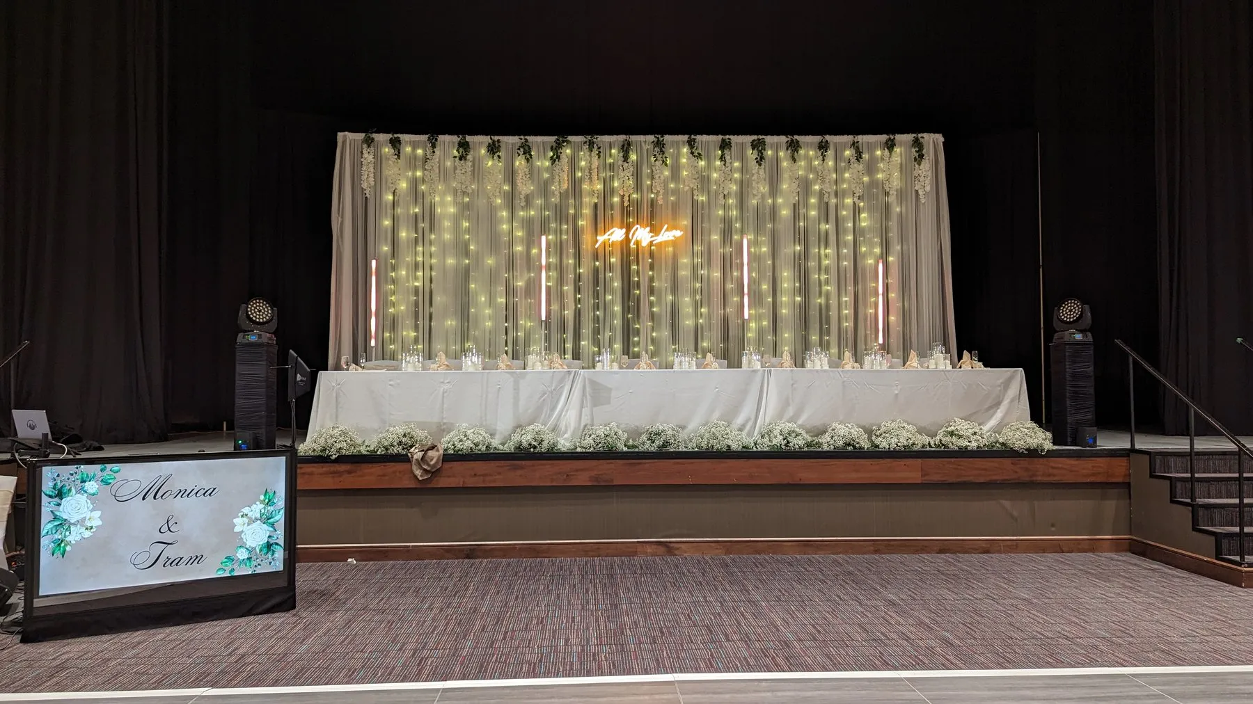 A wedding reception backdrop set up by Cutmaster Music at Sandia Resort, with string lights, greenery, and a lit 'All My Love' sign